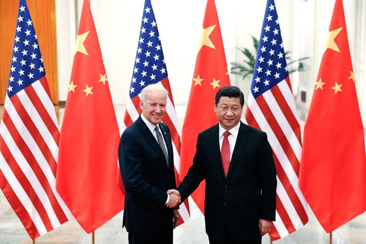 Foto yang diambil pada 4 Desember 2013 memerlihatkan Joe Biden, saat itu Wakil Presiden Amerika Serikat (AS), berjabat tangan dengan Presiden China Xi Jinping di Aula Besar Rakyat di Beijing.