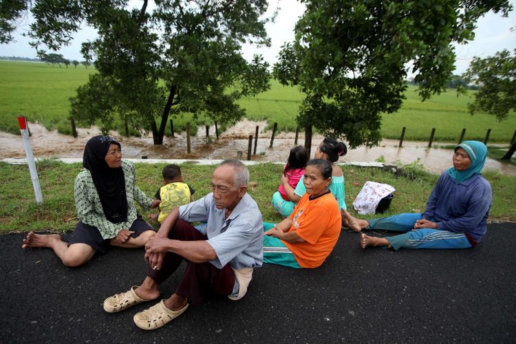 Warga Desa Danareja, Kelurahan Luwung Bata, Kecamatan Tanjung, Brebes mengungsi di tol Kanci -Pejagan akibat banjir yang merendam desa mereka, Jumat (23/2/2018). Luapan Sungai Cisanggarung ini mengakibatkan ratusan rumah warga dan ratusan hektar areal pertanian terendam banjir.