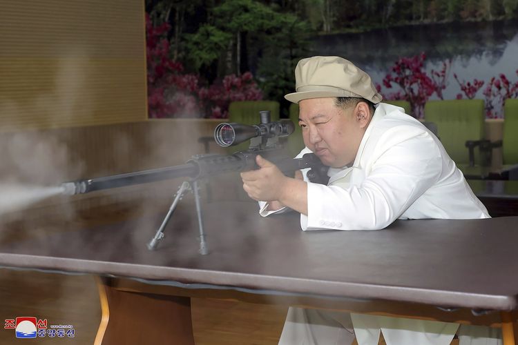 Pemimpin tertinggi Korea Utara Kim Jong Un mencoba sebuah senapan saat melakukan inspeksi tiga hari di pabrik senjata pada 3-5 Agustus 2023.