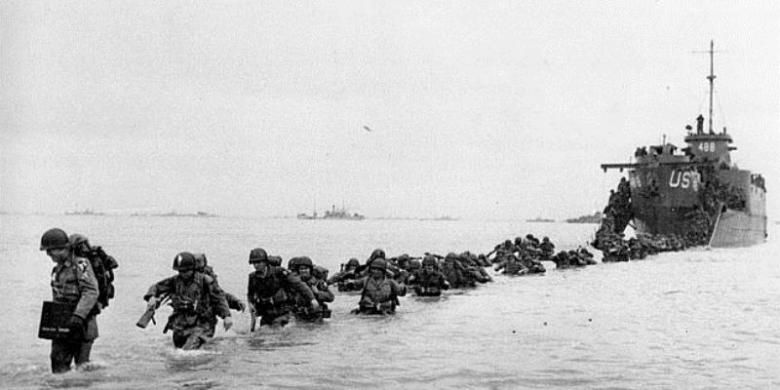 Pasukan AS keluar dari sebuah kapal pendarat yang mengantarkan mereka ke Pantai Normandia pada 6 Juni 1944. Operasi militer bertajuk Operasi Overlord itu dianggap salah satu operasi militer paling menentukan dalam Perang Dunia II.