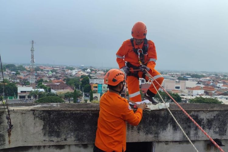 Petugas Damkar dari BPBD Kota Pasuruan sedang menyelamatkan drone yang tersangkut di water toren setinggi 20 meter, Kamis (11/12/2025).