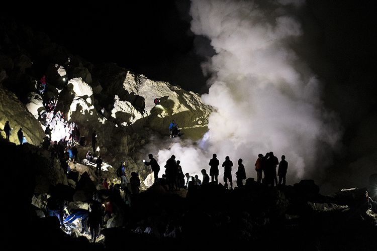 Siluet puluhan wisatawan mengabadikan api biru (Blue Fire) di kawah Ijen, Banyuwangi, Jawa Timur, Sabtu (23/6/2018). Kawah Ijen dengan kedalaman 200 meter menjadi salah satu dari dua lokasi di dunia yang memiliki fenomena api biru selain Islandia, membuat Ijen menjadi tujuan utama pendaki dari berbagai pelosok negeri hingga mancanegara.