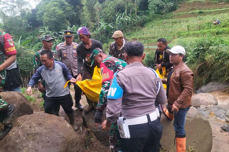 Petugas kepolisian dan warga saat mengevakuasi jenazah warga Kecamatan Kertasari yang meninggal akibat terbawa arus banjir bandang pada Selasa (23/4/2024)