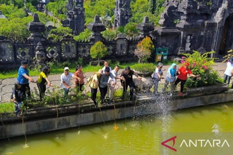 Anggota Dewan Perwakilan Daerah Made Mangku Pastika bersama perwakilan komunitas peduli lingkungan Bali Tresna Sujati saat menuangkan eco enzyme di kolam Monumen Perjuangan Rakyat Bali Denpasar, Selasa (6/2/2024).