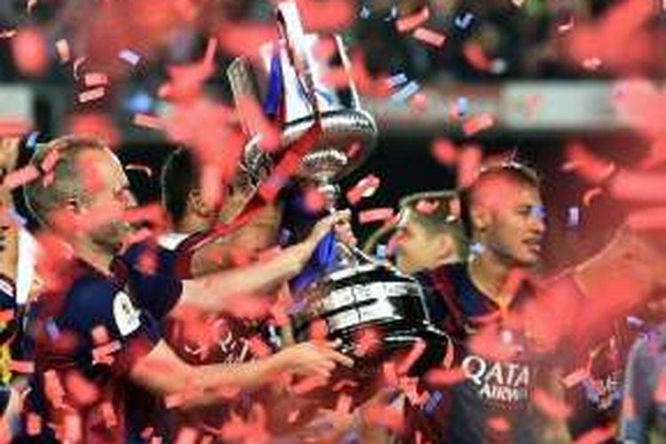 Gelandang Barcelona, Andres Iniesta, mengangkat trofi Copa del Rey seusai partai final kontra Athletic Bilbao di Stadion Camp Nou, 30 Mei 2015.