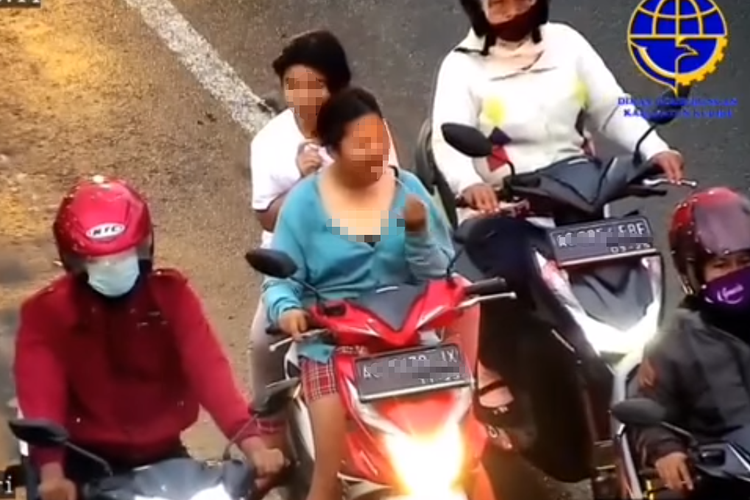 Tangkapan layar video viral pengendara motor dan penumpangnya sama-sama tidak memakai helm serta masker.