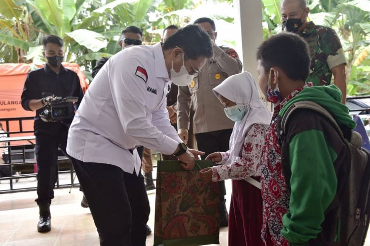 Seorang anak peserta vaksinasi Covid-19 mendapat bingkisan makanan ringan dari Penjagub Gorontalo Hamka Hendra Noer. Vaksinasi ini digelar Korem 133 Nani Wartabone di markas Batalyon 713/ Satya Tama, Kabupaten Gorontalo.