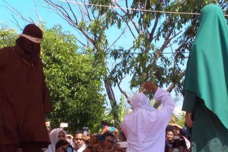 Terpidana Cambuk mengangkat tangannya meminta agar algojo menghentikan cambukannya karena merasa kesakitan. TIm Medis menyatakan terpidana mengalami psikis shock, sehingga Jaksa harus menghentikan ekskusi cambuk ditengah jalan.  Terpidana divonis 26 kali cambukan karena melanggar qanun jinayah pasal 25 ayat 1 tentang ikhtilat.