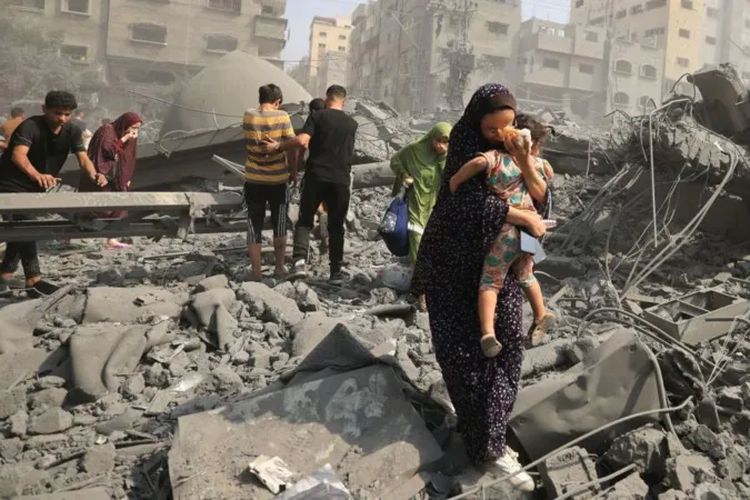 Sejumlah orang Palestina berupaya menjauh dari reruntuhan bangunan menyusul serangan udara Israel terhadap Masjid Sousi di Kota Gaza, Oktober 2023.