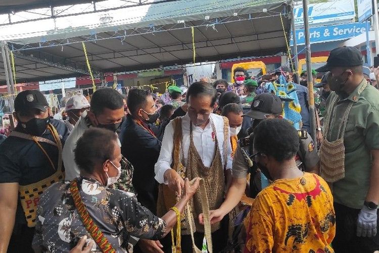 Presiden Joko Widodo dikelilingi mama-mama Papua yang menawarkan noken buatannya di Jayapura, Sabtu (13/11/2021).