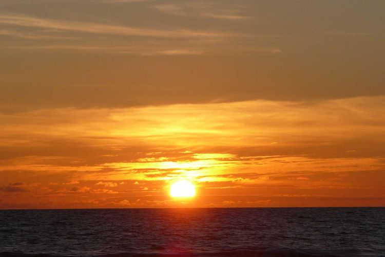 Ilustrasi matahari terbenam di Pantai Legian, Bali.