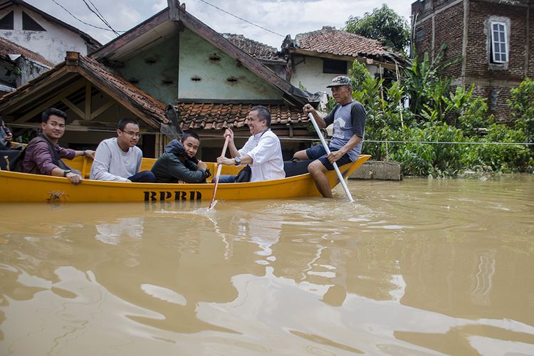 Warga menggunakan perahu melintasi banjir yang menggenangi kawasan Baleendah, Kabupaten Bandung, Jawa Barat, Minggu (26/1/2020). Sedikitnya 40 ribu jiwa dan tujuh ribu rumah dari lima kecamatan di kawasan Bandung Selatan tersebut terdampak banjir akibat luapan Citarum serta intensitas curah hujan yang tinggi.