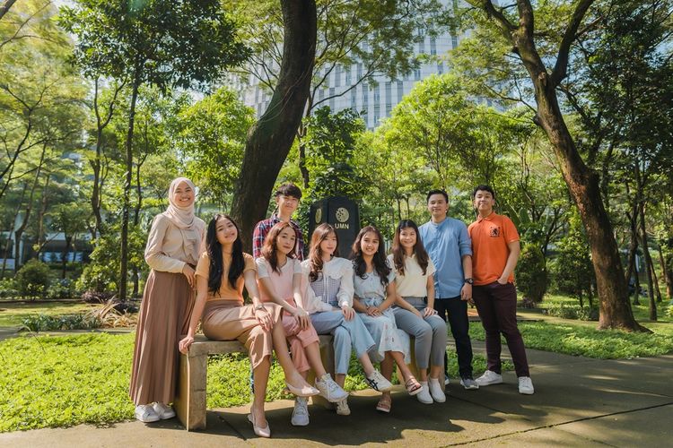 Mahasiswa UMN duduk bersama di lingkungan terbuka dipenuhi pepohonan yang rindang (foto diambil sebelum pandemi).