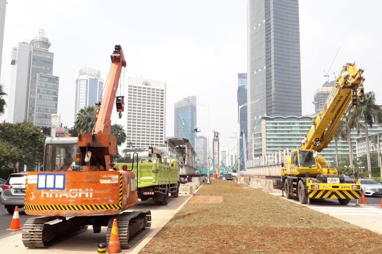 Crane dan truk diletakkan di jalur busway sekitar Bundaran HI, Selasa (31/7/2018)