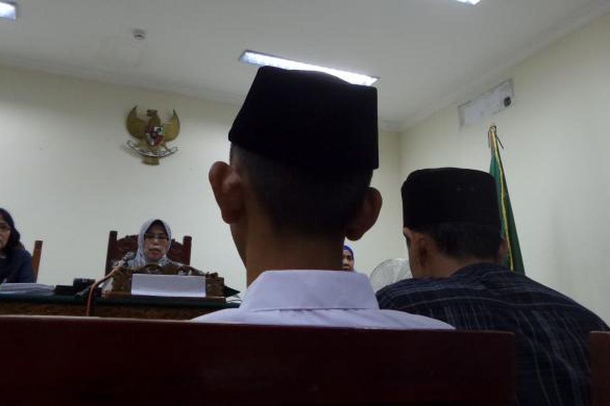 Remaja terdakwa kasus pembunuhan karyawati EF (19), RA (16), mendengarkan putusan di Pengadilan Negeri Tangerang, Kamis (16/6/2016). Pada sidang putusan ini, RA didampingi ayahnya, Nayudin, yang duduk di sampingnya. 