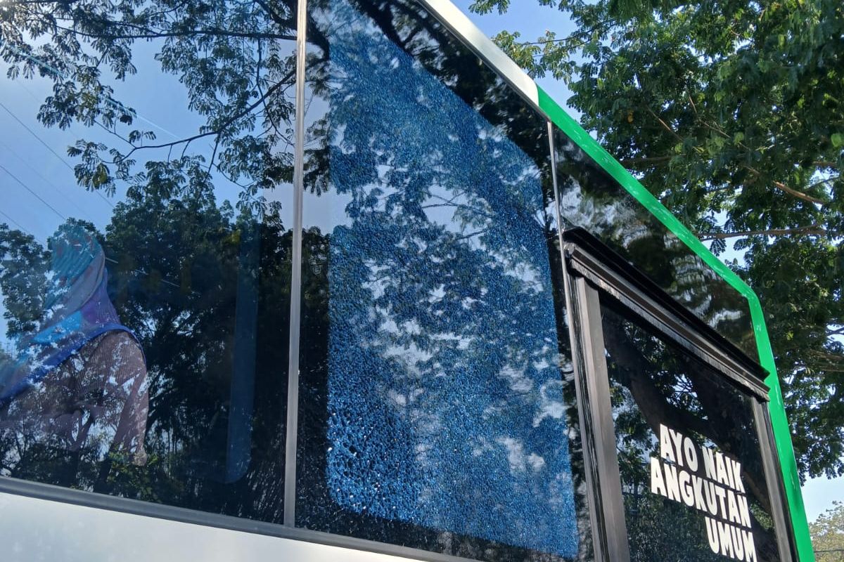 Kaca Bus Trans Jatim Surabaya-Bangkalan yang retak dilempar batu oleh orang tak dikenal, Minggu (6/10/2024).