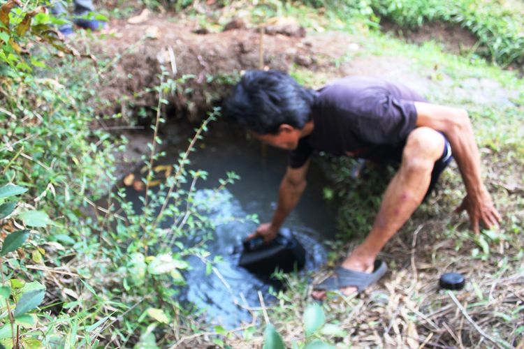 Seorang warga Cianjur, Jawa Barat tengah mengambil air dari cerukan di Kampung Cikole, Desa Cibaregbeg, Kecamatan Cibeber, Kabupaten Cianjur, Jawa Barat menyusul krisis air bersih di wilayah tersebut akibat musim kemarau dan bendung irigasi jebol.