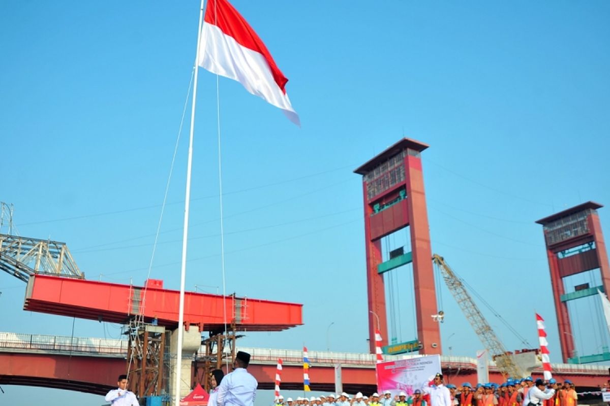 Sejumlah pekerja Light Rail Transit (LRT) melakukan upacara bendera di atas ponton di bantaran Sungai Musi Palembang, Sumatera Selatan, Kamis (17/8/2017). Untuk memperingati HUT ke-72 RI, Waskita Karya menggelar peringatan hari kemerdekaan dengan upacara dan sejumlah perlombaan bagi pekerja LRT di Palembang.