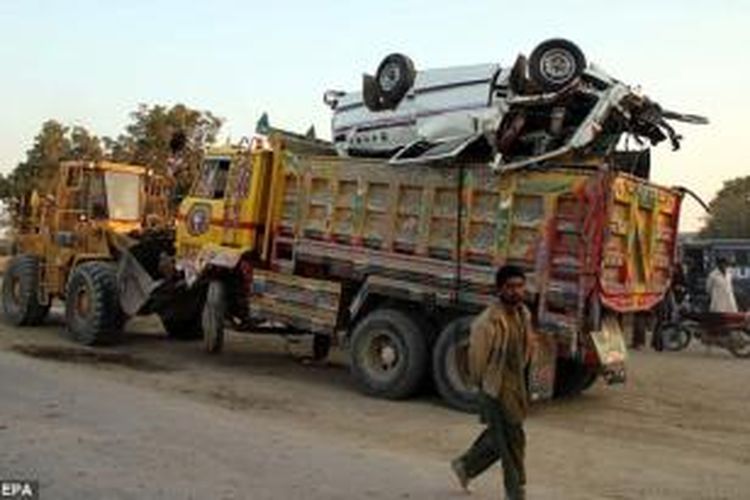 Sebuah alat berat menarik truk dan bus sekolah yang terlibat dalam tabrakan maut di distrik Nawab Shah, Provinsi Sindh, Pakistan. Dalam kecelakaan ini 19 orang anak-anak meninggal dunia.
