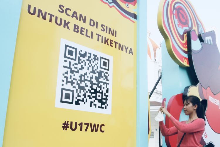Seorang warga sedang membeli tiket Piala Dunia U17 2023 Indonesia secara online dengan menggunakan barcode yang tersedia di tempat-tempat umum yang ada di Surabaya. 