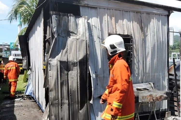 Petugas pemadam kebakaran memeriksa di sekitar kontainer yang terbakar di taman bermain di George Town, Penang, Malaysia, pada Minggu (13/1/2019).