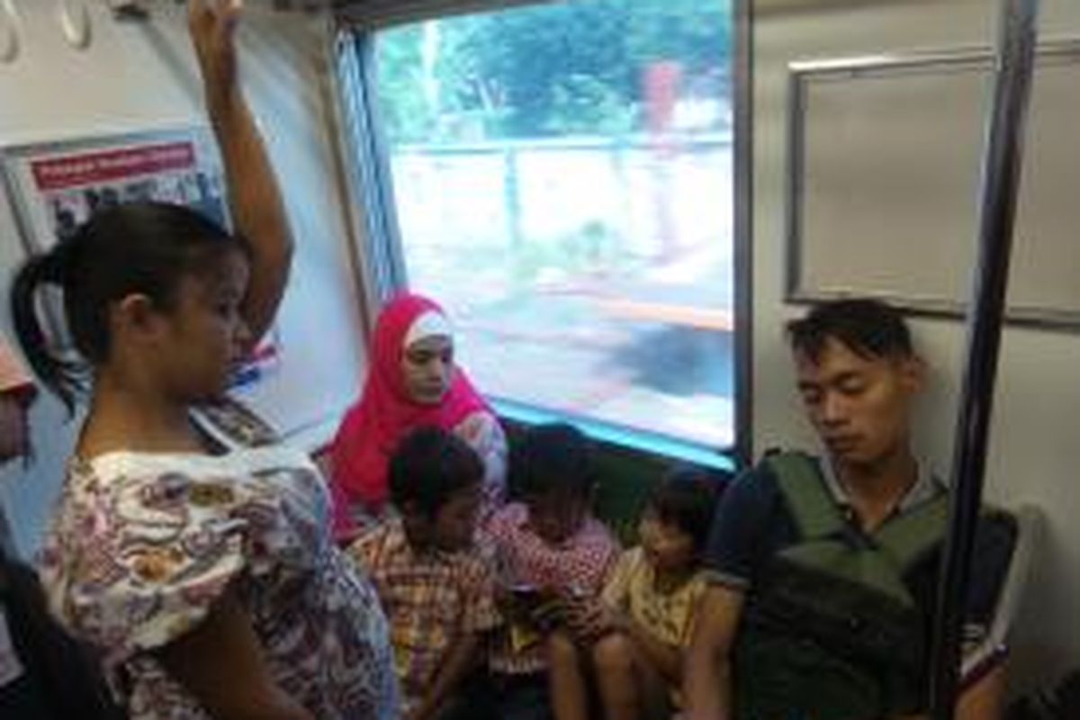 Salah seorang pria penumpang KRL Commuter Line yang tampak tertidur pulas di kursi prioritas saat ada seorang ibu hamil berdiri bergelantungan di depannya. Situasi ini terjadi di dalam KRL rute Bogor-Jakarta Kota, Rabu (13/5/2015) 