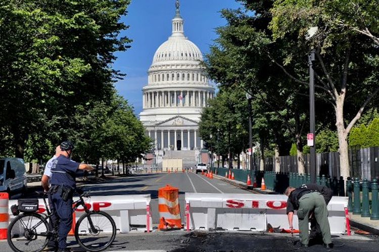 Petugas Polisi Gedung Capitol AS bekerja di dekat barikade polisi di Capitol Hill di Washington, DC, pada 14 Agustus 2022. 
