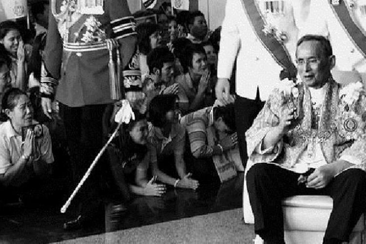 Raja Thailand Bhumibol Adulyadej yang duduk di kursi roda membalas sambutan warga yang menunggunya saat kembali ke Rumah Sakit Siriraj dari Istana Agung di Bangkok, Thailand, tempat dia memberikan sambutan dalam perayaan ulang tahunnya yang ke-84, Senin (5/12/2011).