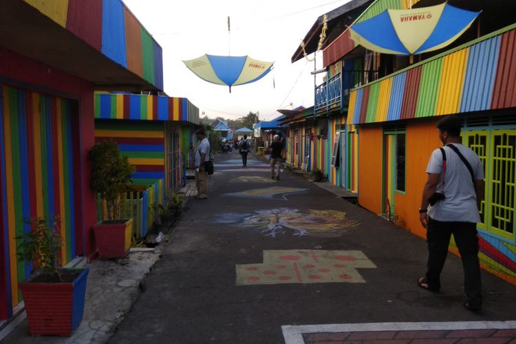 Masyarakat beraktivitas di depan rumah yang dikenal dengan Kampung Pelangi di Kota Pangkalan Bun, Kotawaringin Barat, Kalimantan Tengah, Sabtu (17/2/2018). Kampung Pelangi merupakan salah satu obyek wisata buatan yang kini dikembangkan oleh Pemerintah Kabupaten Kotawaringin Barat untuk menarik kunjungan wisatawan nusantara maupun mancanegara.