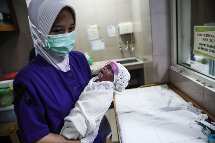 Perawat merawat bayi yang baru lahir di ruangan Perina di Rumah Sakit Ibu dan Anak (RSIA) Tambak, Jakarta Pusat, Rabu (15/4/2020). Rumah Sakit Ibu dan Anak Tambak, mulai 12 April membuat kebijakan bahwa bayi yang baru lahir di RS tersebut dipakaikan alat pelindung wajah (face shield), penggunaan pelindung wajah sebagai upaya pencegahan penyebaran virus korona atau covid-19.