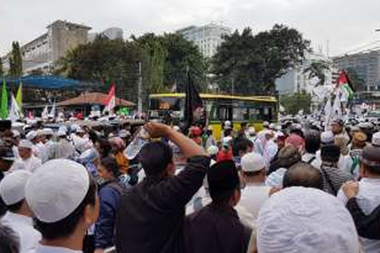 Sejumlah kendaraan pribadi tertahan di tengah Jalan Medan Merdeka Timur, Jakarta Pusat, Jumat (14/10/2016). Laju kendaraan tertahan keramaian massa ormas keagamaan yang mendemo Gubernur DKI Jakarta Basuki Tjahaja Purnama.