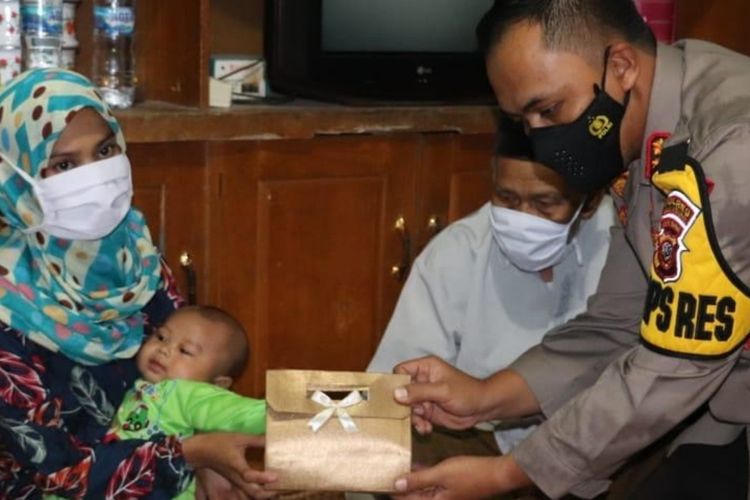 President Jokowi through Sukabumi Police chief Lukman Syarif (Right) gives money to S at her rented house in Sukabumi regency in West Java on Saturday, April 3.