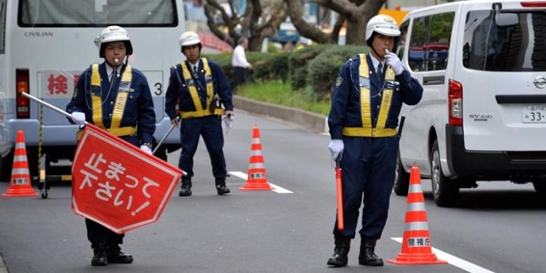 Sejumlah petugas polisi Jepang memeriksa kendaraan yang melintas di dekat kedutaan besar AS di Tokyo. Menjelang kunjungan Presiden Barack Obama, sebanyak 16.000 personel polisi dikerahkan untuk mengamankan kunjungan bersejarah itu,