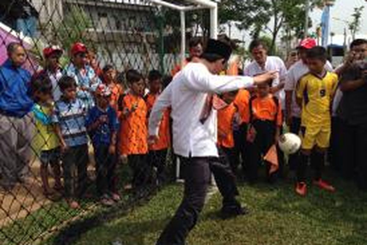 Gubernur DKI Jakarta Basuki Tjahaja Purnama menepis bola yang ditendang oleh anak-anak di ruang publik terpadu ramah anak (RPTRA) Kembangan, Jakarta Barat, Jumat (5/6/2015).