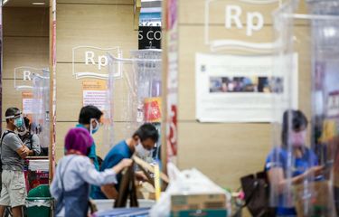 Pembeli menggunakan masker saat melakukan pembayaran dari balik plastik pembatas di supermarket AEON Mal Serpong, Tangerang, Banten, Selasa (26/5/2020).  Pemerintah Indonesia bersiap menerapkan tatanan baru (new normal) dalam waktu dekat. Salah satunya dengan mulai membuka pusat perbelanjaan secara bertahap di bulan Juni mendatang.