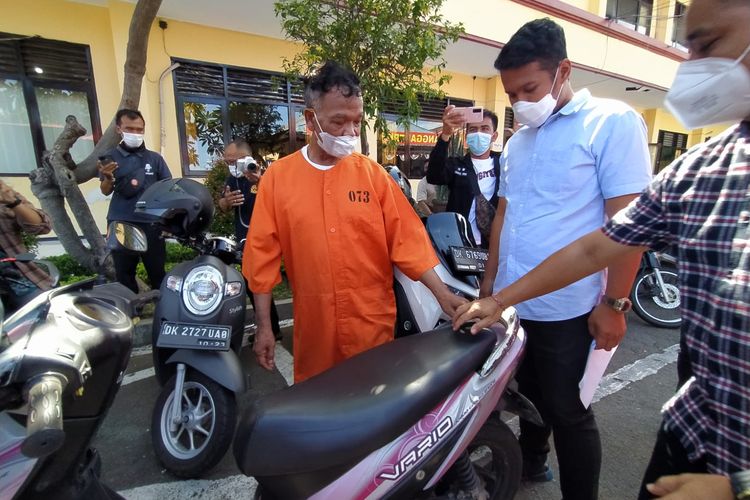 Residivis spesialis pencurian barang dalam jok motor, GS (56), memperagakan aksinya.