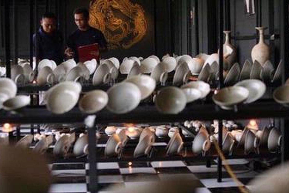 Staf pelaksana lelang melakukan persiapan tahap akhir, pada benda muatan kapal tengelam (bmkt) dari bangkai kapal di perairan Cirebon yang telah ditata rapi untuk dapat dilihat calon peserta lelang di sebuah gudang penyimpanan di Jakarta, Senin (3/5/2010). Peserta yang dapat mengikuti lelang pada Rabu 5 Mei, dapat mengikuti lelang dan melihat langsung ke dalam gudang dengan mendaftar di sekertariat pelelangan Panitia Nasional BMKT dan menyetorkan uang jaminan lelang sebesar 16 juta dolar AS. KOMPAS/LASTI KURNIA