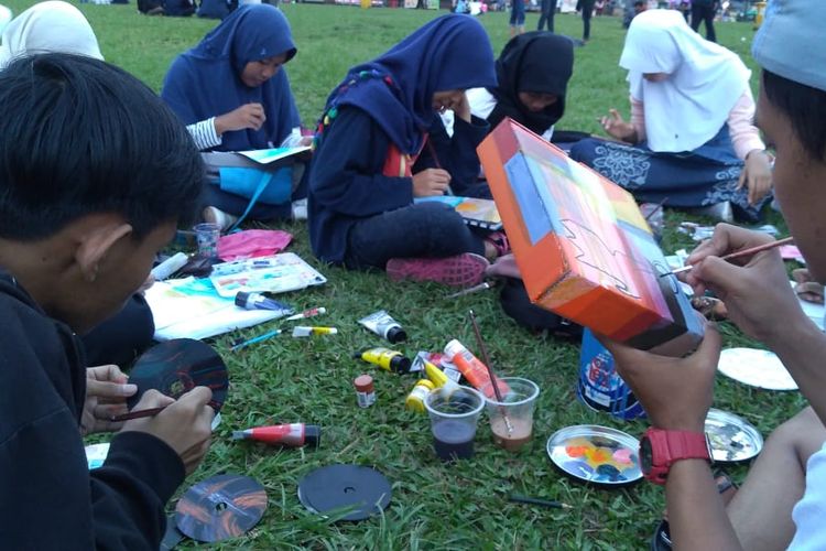 Siswa SMK Negeri 1 Purwokerto ngabuburit sambil menggambar di Alun-alun Purwokerto, Jawa Tengah, Kamis (16/5/2019).