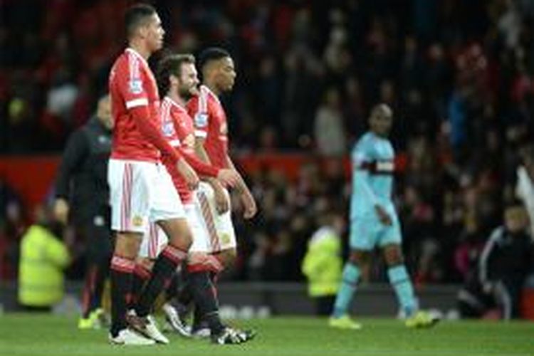 Tiga pemain Manchester United (dari kiri ke kanan), Chris Smalling, Juan Mata dan Anthony Martial berjalan meninggalkan lapangan pertandingan setelah mereka bermain imbang 0-0 melawan West Ham United di Old Trafford, Sabtu (5/12/2015), pada lanjutan Premier League.