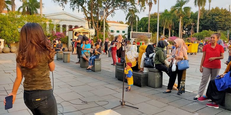 Pengunjung bernyanyi dan disaksikan langsung oleh sesama pengunjung wisata Kota Tua, Rabu (27/11/2019). Dengan membayar Rp 20.000 pengunjung bisa merikues dan menyanyikan lagu sendiri diiringi musik Akustik Kota Tua.