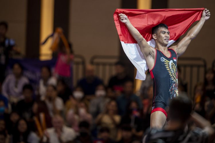 Pegulat putra Indonesia Muhammad Aliansyah membentangkan bendera Merah Putih seusai mengalahkan pegulat Vietnam Manh Hung Bui pada pertandingan gulat gaya Yunani Romawi (Greco Roman) 67 kilogram putra SEA Games 2023 di Chroy Changvar International Convention & Exhibition Center, Phnom Penh, Kamboja, Minggu (14/5/2023). Muhammad Aliansyah berhasil meraih medali emas usai mengalahkan pegulat Vietnam dengan skor 13-6, sehingga menduduki peringkat pertama dengan total 25 poin yang diikuti pegulat Vietnam Manh Hung Bui dengan 20 poin dan pegulat Filipina Chlovelle Van Ygona Adolfo dengan 15 poin. ANTARA FOTO/M Agung Rajasa/nym.