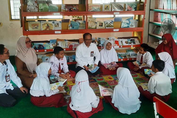 Sekretaris Badan Bahasa Hafidz Muksin (tengah) berdialog dengan siswa SD di perpustakaan sekolah tentang buku bacaan bermutu.