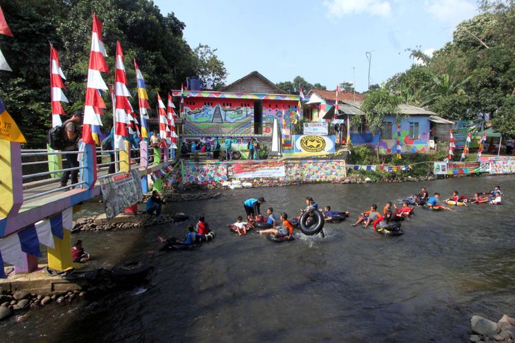 Sejumlah anak susur sungai menggunakan ban bekas atau ngalun di aliran Sungai Ciliwung Kampung Warna-warni, Desa Katulampa, Kota Bogor, Jawa Barat, Rabu (14/9/2017).