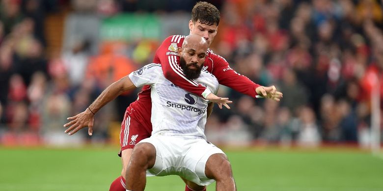 Bryan Mbeumo (depan) berduel dengan Milos Kerkez dalam pertandingan sepak bola Liga Inggris antara Liverpool vs Manchester United di Anfield di Liverpool, barat laut Inggris pada 19 Oktober 2025. (Foto oleh PETER POWELL / AFP)
