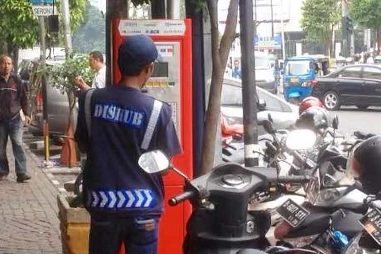 Seorang petugas sedang mendaftarkan kendaraan yang hendak parkir di Jalan Sabang, Jakarta Pusat, ke mesin parkir meter, Kamis (3/5/2017).