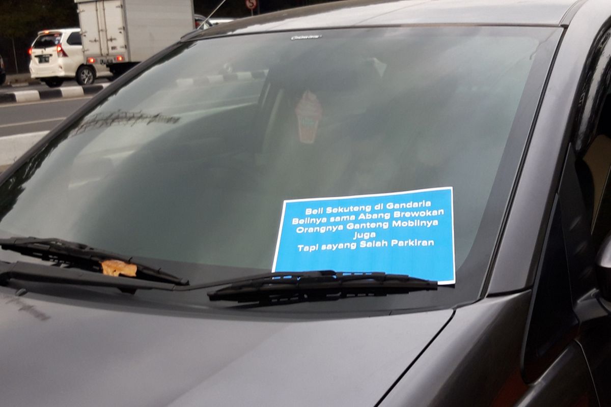 Salah satu mobil yang diletakkan pantun tentang larangan parkir di bahu jalan oleh anggota Qlue, Jumat (26/10/2018)