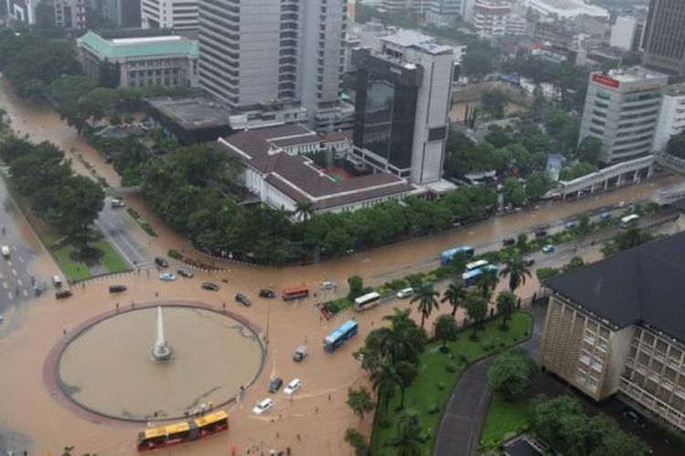 Banjir di kawasan bundaran air mancur di samping Patung Arjuna Wiwaha, Jalan MH Thamrin, Jakarta, Senin (9/2/2015). Curah hujan yang tinggi mengakibatkan sejumlah tempat di ibu kota terendam banjir. KOMPAS / LASTI KURNIA