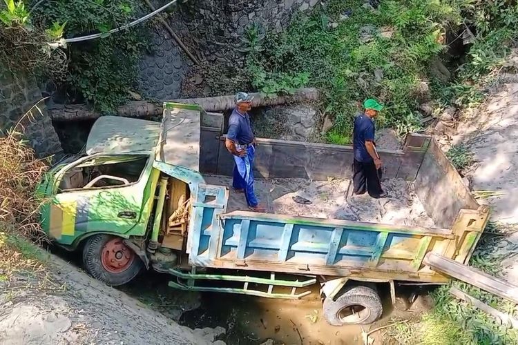 TERJUN MASUK SUNGAI-- Gegara sopir hilang kendali, sebuah truk bermuatan pasir terjun masuk ke dalam sungai di Desa Pomahan, Kecamatan Pulung, Kabupaten Ponorogo, Jawa Timur, Senin (28/8/2023).
