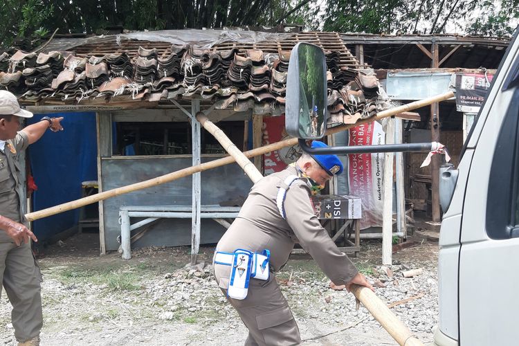 Tim Satpol PP Kabupaten Ngawi membongkar warung kopi yang berada di area Alas Malang, Desa Karangjati, Kecamatan Karangjati, Kabupaten Ngawi, Jawa Timur, Selasa (21/1/2025).