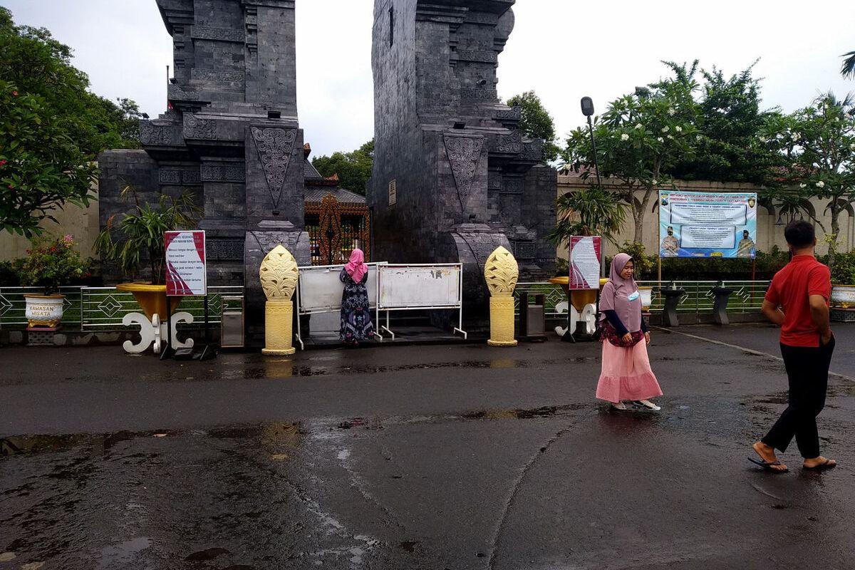 Seorang perempuan berdoa di depan pintu gerbang Makam Bung Karno yang mendadak ditutup oleh Wali Kota Blitar, Jumat (31/12/2021)